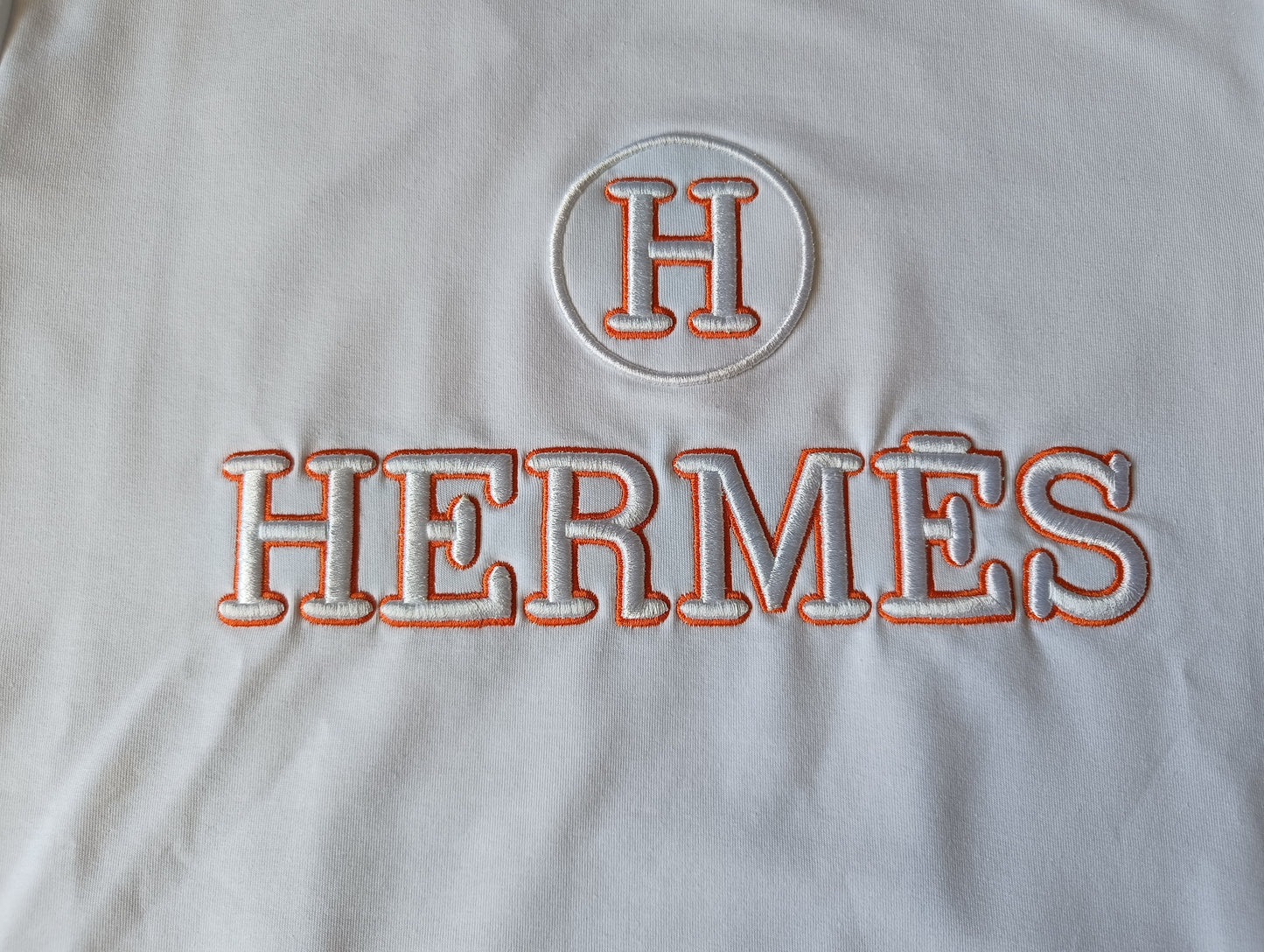 Детайл от лого Hermes – бяла блуза